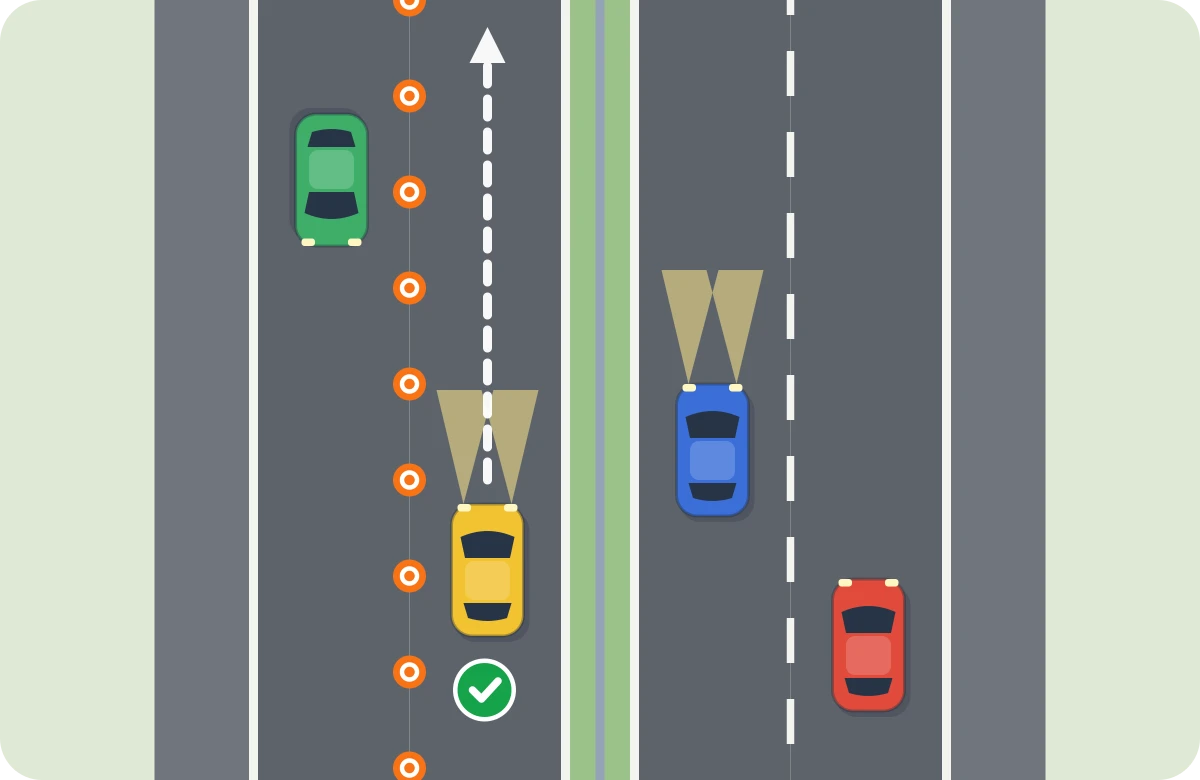 El amarillo circula por el carril abierto en la calzada contraria, separado con conos. Lleva luz de cruce; el azul, en el carril contiguo de su calzada, también.